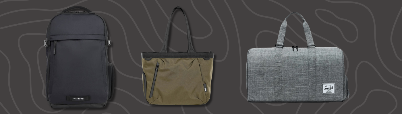 Three minimalist bags, including a black backpack, olive tote, and gray duffel, on a dark, patterned background.