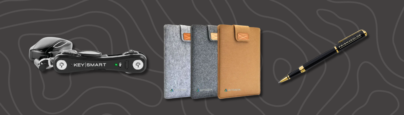 KeySmart organizer with keys, felt notebooks, and a co-branded pen arranged on a dark, patterned background
