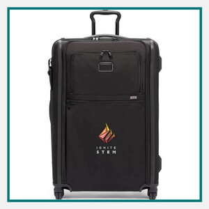 Black TUMI™ Alpha Hybrid Medium Trip Expandable 4 Wheeled Packing Case with Ignite STEM logo on the front, featuring a telescopic handle, front zipper compartments, and four spinner wheels against a white background.