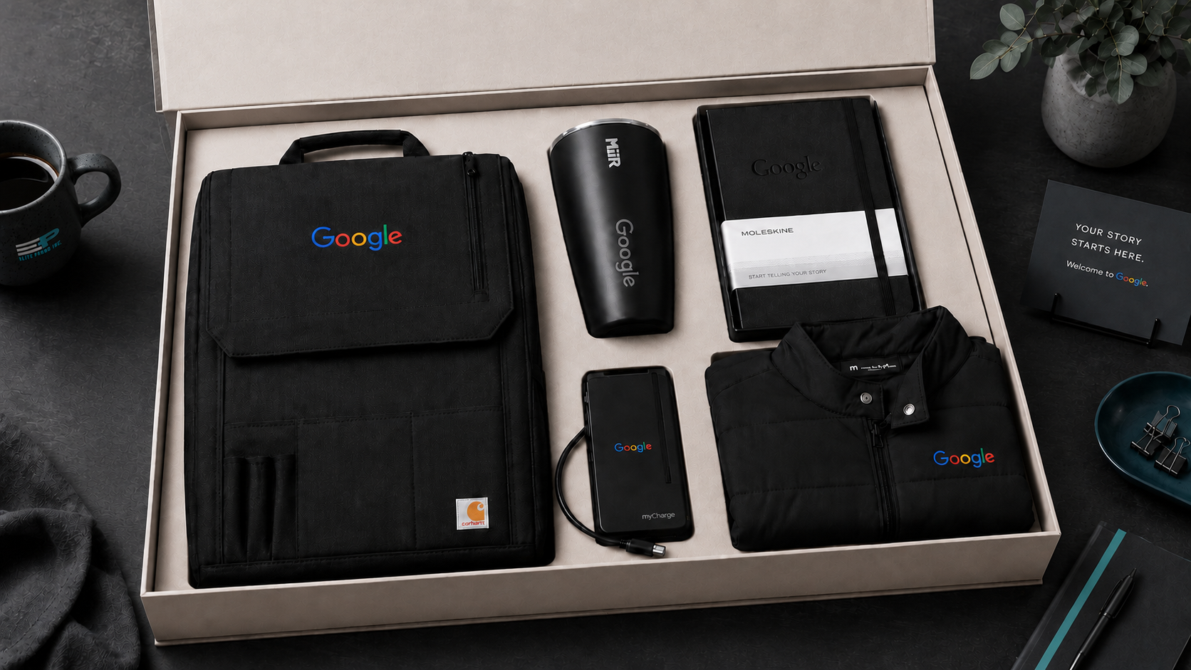 Best employee welcome kits image featuring a Google branded sales team travel kit with Carhartt organizer bag, MiiR tumbler, Moleskine notebook, power bank, and black jacket in a premium gift box.