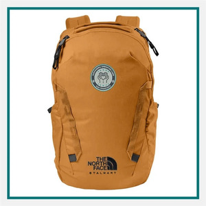 The North Face Stalwart Backpack in tan with multiple zippered compartments, side pockets, front straps, a circular embroidered logo, and The North Face branding.