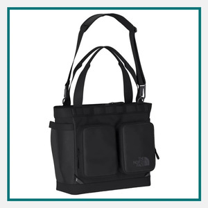 North Face 25L Base Camp Voyager Tote in black with dual carry handles, an adjustable shoulder strap, two front zippered pockets, and The North Face logo on the front.